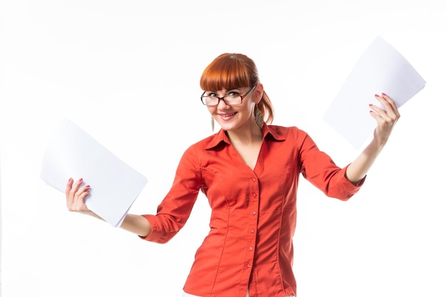 Plano medio horizontal de una joven adulta caucásica con ropa elegante sosteniendo documentos y un bolígrafo sonriendo al espacio de copia de la cámara
