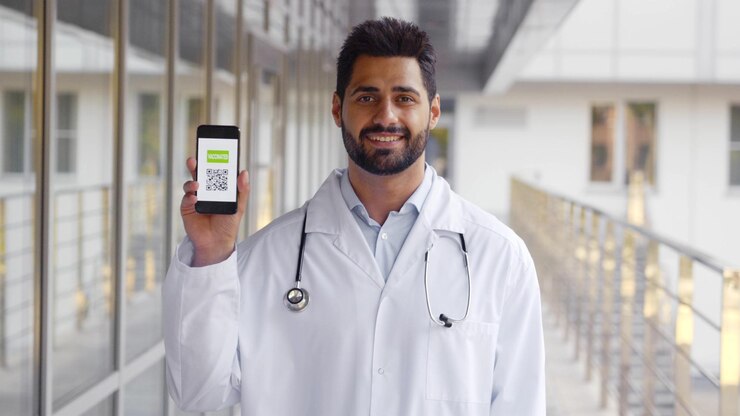 Plano medio del médico masculino mirando la cámara con certificado de vacunación electrónico en el teléfono celular