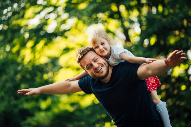 Foto plano medio padre e hija sonriendo a la cámara