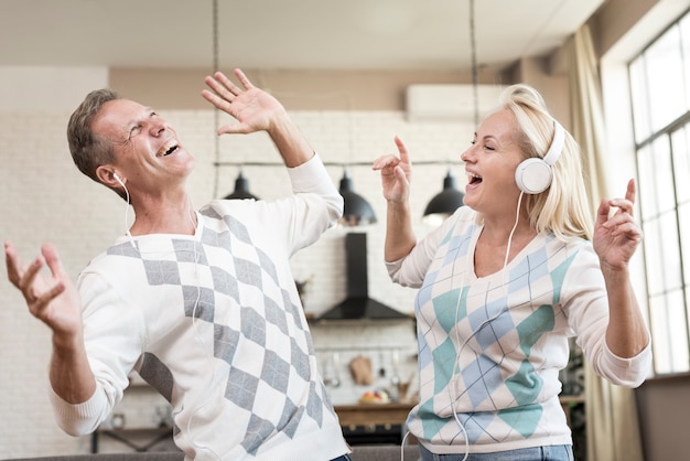 Plano medio pareja feliz con auriculares en el interior