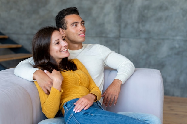 Foto plano medio de pareja viendo la tele