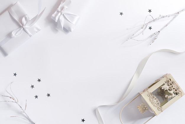 plano de Navidad blanco con cajas de regalo linterna de vela antigua y decoración de confeti