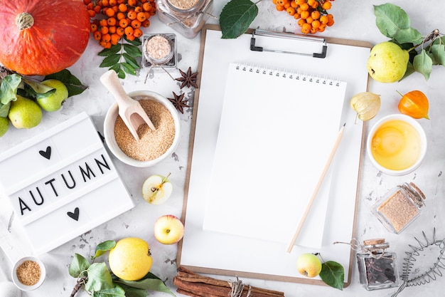 Plano de otoño con caja de luz con la frase Otoño. Vista superior. Ingredientes alimentarios para hacer pastel de calabaza de otoño sobre un fondo de piedra blanca.