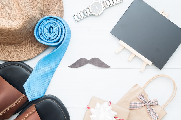 El plano pone la corbata y las gafas del color azul en fondo de madera blanco del vintage