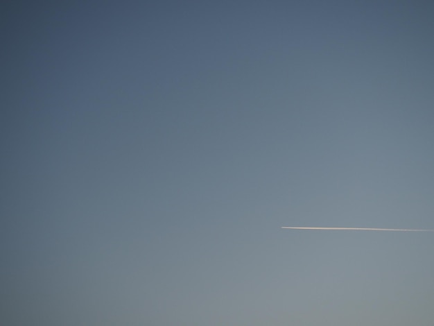 Plano y sendero en el cielo azul de la tarde Fondo abstracto sobre un tema espacial o aerodinámico Gradiente de color