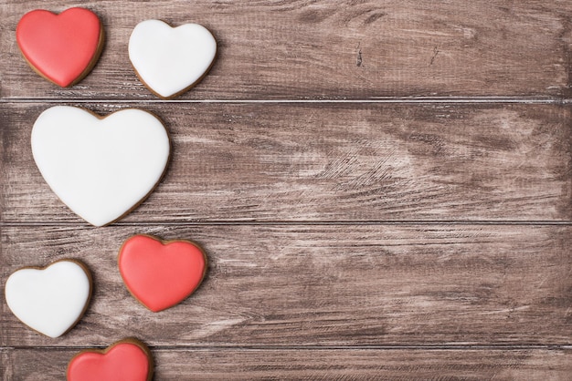 Plano superior laicos cerrar ver foto de deliciosas galletas sabrosas en forma de corazones sobre fondo rústico marrón