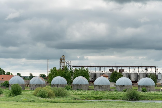 Planta de agroprocesamiento y fabricación para el almacenamiento y procesamiento de cultivos de granos y silos vista del antiguo elevador del granero Grandes barriles de plata de hierro para procesamiento y secado