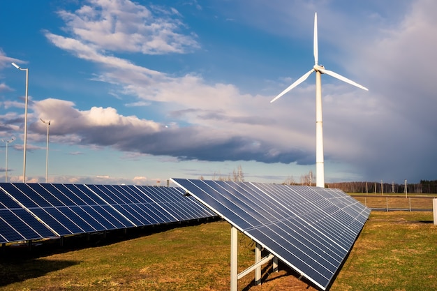 Planta de células solares y generadores eólicos bajo un cielo azul