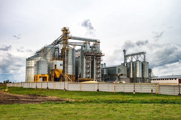 Planta de agroprocessamento para processamento e silos para secagem, limpeza e armazenamento de cereais de farinha de produtos agrícolas e grãos com belas nuvens