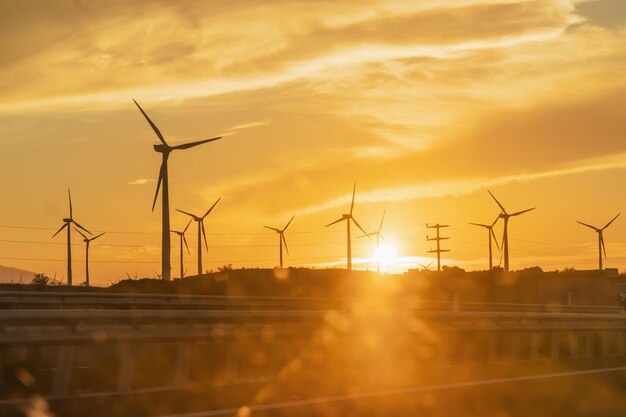 Foto planta de geração de energia eólica ao pôr-do-sol a partir de uma janela de carro energia renovável contra o aquecimento global