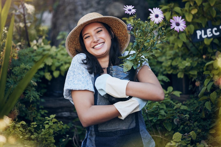 Foto planta de sorriso e retrato de mulher em jardim ao ar livre para sustentabilidade ambiental ou ecologia felicidade da natureza e abraço de pessoas flores para agricultura de viveiro verde ou paisagismo no quintal