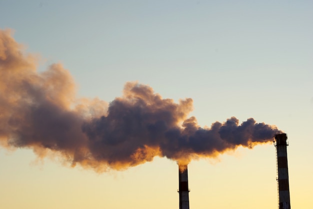 Foto planta de energía con humo bajo el cielo