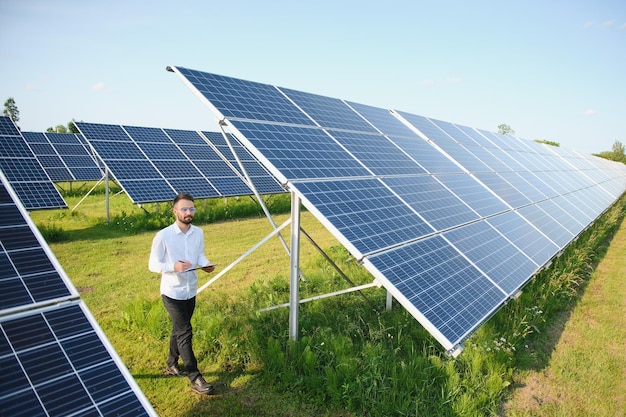 Planta de energía solar Ingeniero sobre un fondo de paneles fotovoltaicos Ciencia energía solar