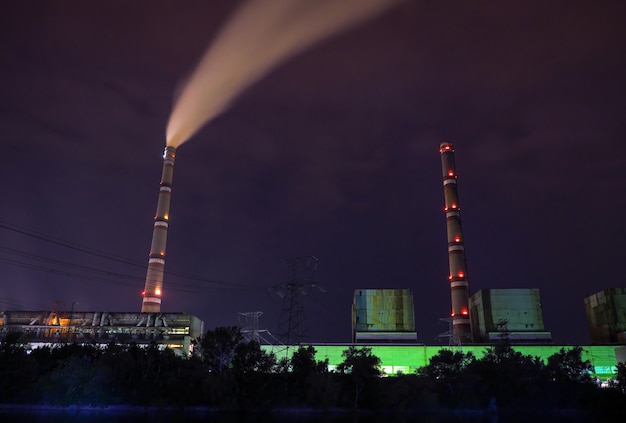 Planta de energía con tuberías por la noche. Foto oscura