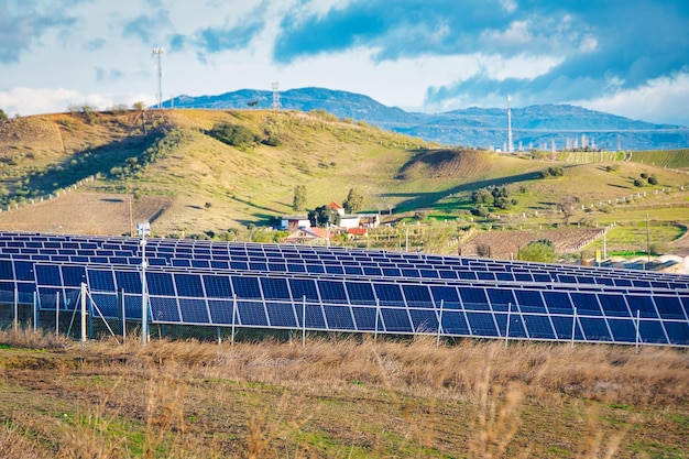 Planta fotovoltaica en el campo con montañas al fondo.