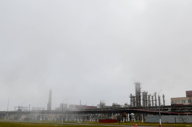 Planta petroquímica de refinería de petróleo en niebla de tiempo nublado
