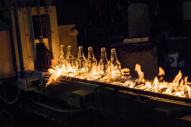 Planta para la producción de botellas de vidrio botellas de vidrio en una cinta transportadora con fuego