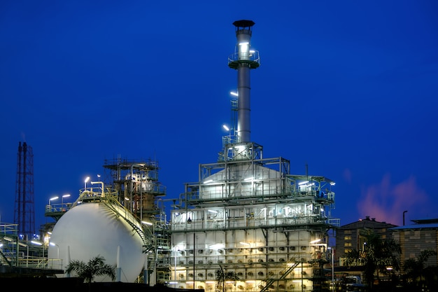 Planta de refinería de petróleo y gas o planta industrial petroquímica sobre fondo de crepúsculo de cielo azul, fábrica de petróleo con cielo de amanecer, horno industrial y pila de humo cadena de hidrocarburos agrietados