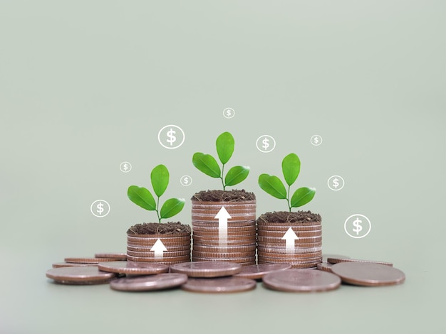 Foto plantas crescendo em pilhas de moedas com setas subindo e ícones de moedas de dólar o conceito de poupar dinheiro investimento financeiro e negócios crescendo