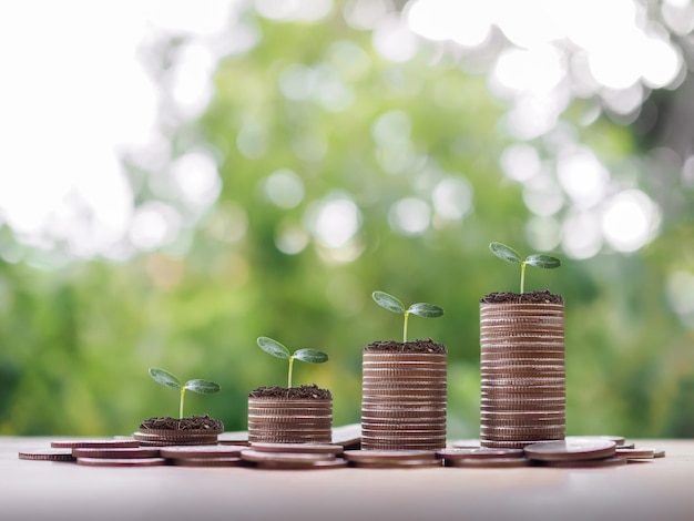 Foto plantas crescendo em uma pilha de moedas o conceito de economizar dinheiro investimento financeiro e crescimento de negócios