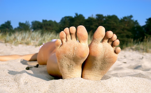 Foto plantas y dedos de los pies de la chica de la playa