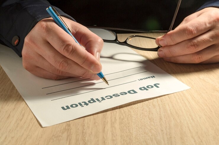 Foto una plantilla de descripción de trabajo para completar con lápiz y manos