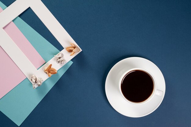 plantilla de marco de fotos hojas de papel de colores y un diseño decorativo en la mesa al lado de una taza de café vista superior