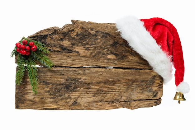 Plantilla de Navidad viejo cartel de madera con gorro de Papá Noel y ramita de abeto sobre fondo blanco.