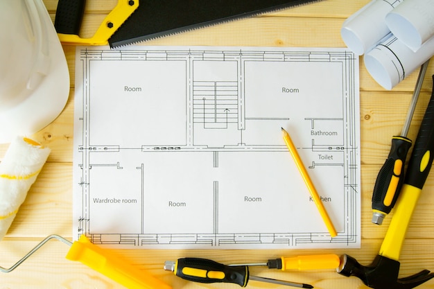 Planung der Reparatur des Hauses. Reparatur. Zeichnungen für Bau-, Säge-, Hammer- und andere Werkzeuge auf hölzernem Hintergrund.