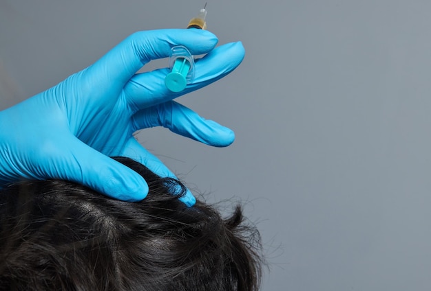 Foto plasma de inyección en el médico cosmetólogo del hombre del pelo de la cabeza