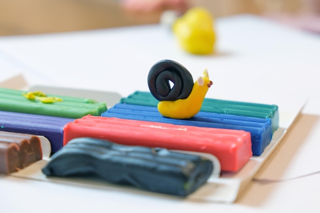 Foto plasticina multicolorida para modelagem e uma estatueta de caracol