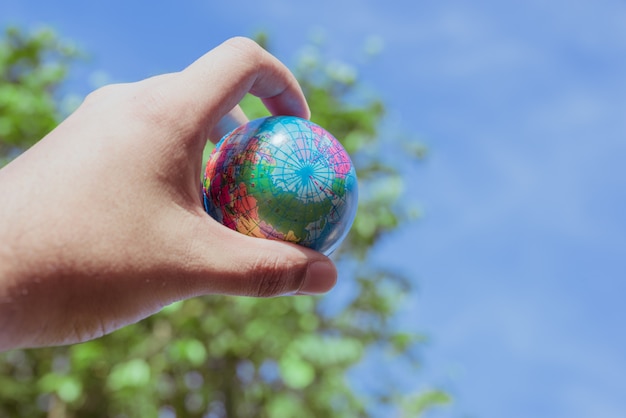 Plástico de preensão de mão do planeta Terra no fundo da natureza. salve o conceito do mundo.