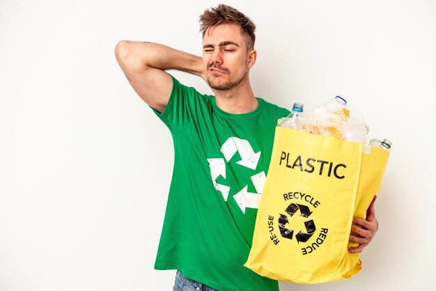 Plástico reciclado jovem homem caucasiano isolado no fundo branco tocando a parte de trás da cabeça, pensando e fazendo uma escolha.