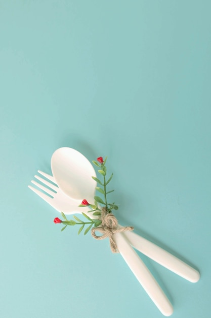 Foto plástico tenedor y cuchara aislado sobre fondo azul.