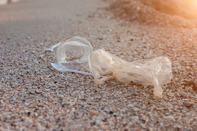 Plastik- und Plastiktüte, Müll auf dem Hintergrund eines Sandstrandes.