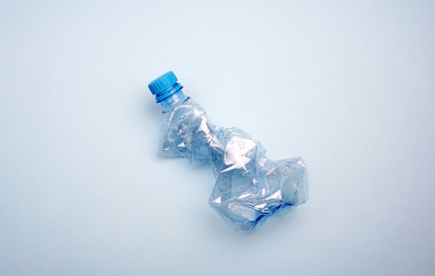 Plastikflasche auf blauem Hintergrund. Minimales Konzept der Meeresverschmutzung