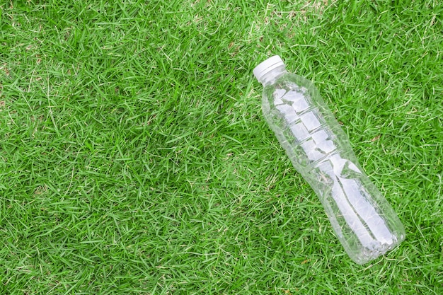 Plastikflasche auf grünem Grashintergrund Recycling- und Verschmutzungskonzept