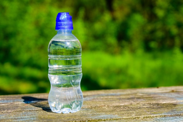 Plastikflasche mit klarem Wasser auf Holztisch