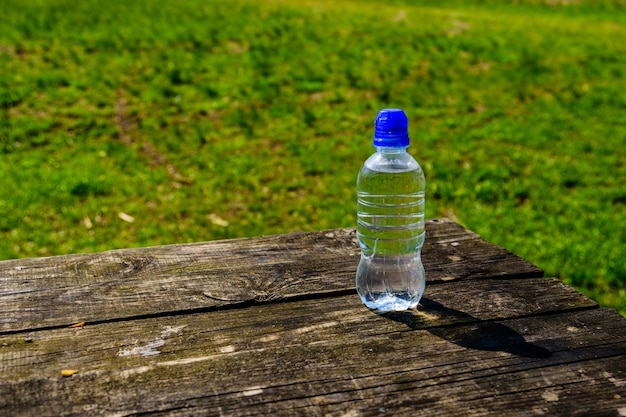 Plastikflasche mit klarem Wasser auf Holztisch