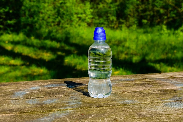 Plastikflasche mit klarem Wasser auf rustikalem Holztisch