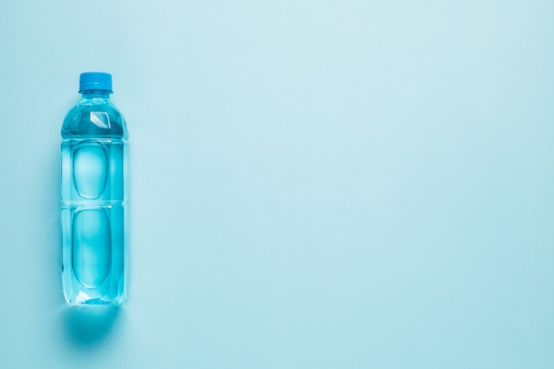 Plastikflasche mit Wasser auf einem farbigen Hintergrund