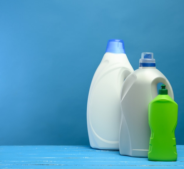 Plastikflaschen mit Waschmitteln auf blauem Hintergrund, Kopierraum