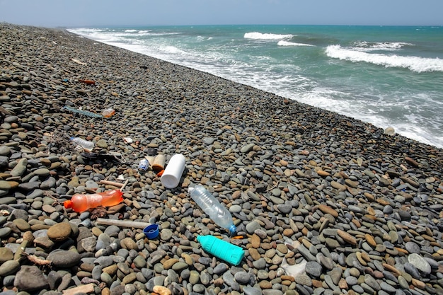 Plastikflaschen Müll am wilden Kieselstrand. Konzept der Ozean- und Meeresvermüllung