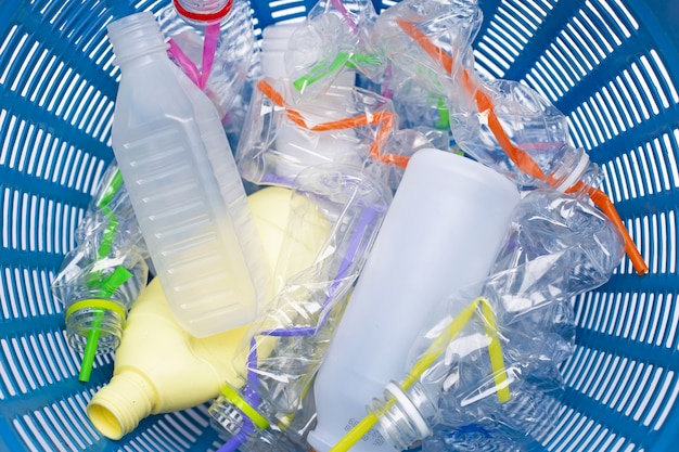 Plastikmüll, Plastikflaschen mit Strohhalmen im Papierkorb