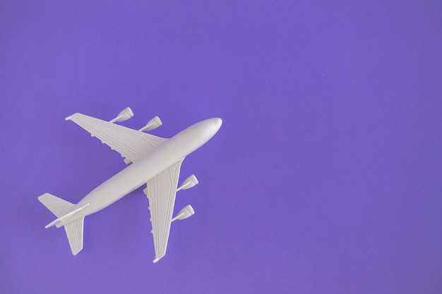 Plastikspielzeugflugzeug auf einem violetten Hintergrund