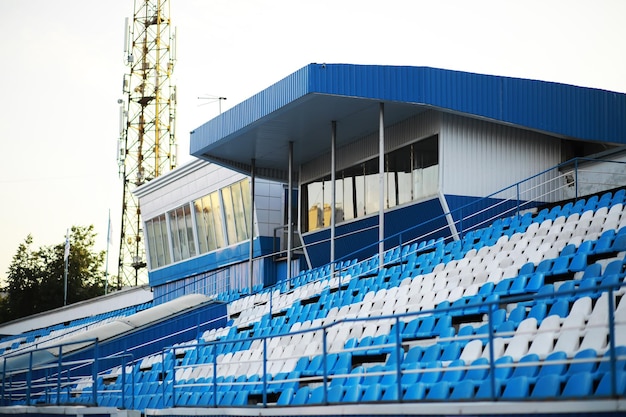 Plastikstühle auf den Tribünen eines Sportstadions Jubeln Sie auf den Tribünen des Stadions