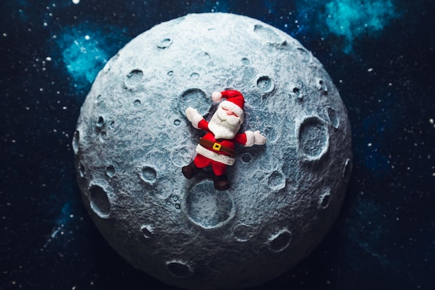 Plastilin-Weihnachtsmann liegt auf der Mond-Weihnachtskarte