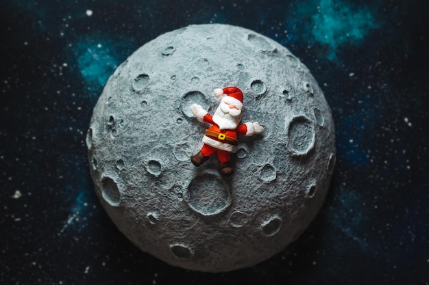 Plastilin-Weihnachtsmann liegt auf der Mond-Weihnachtskarte