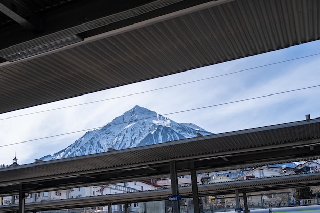Plataforma en la estación de tren con fondo de montaña nevada Suiza