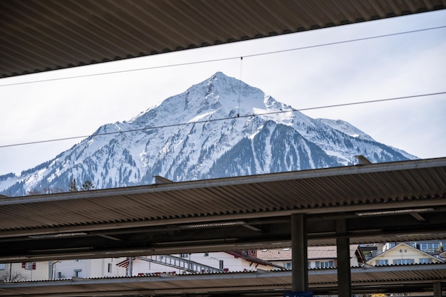 Plataforma en la estación de tren con fondo de montaña nevada Suiza